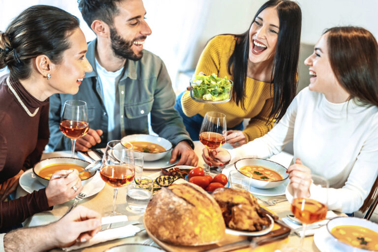 friends laughing around a dinner table