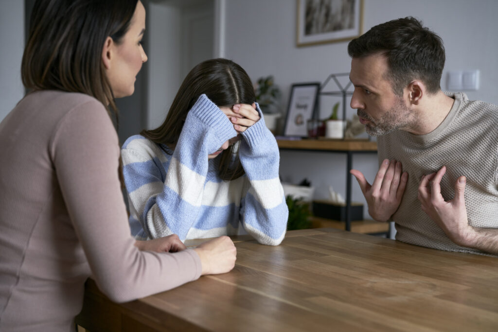 A photo of parents screaming at their teenage daughter about substance use concerns