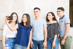 A group of teens with high self worth who are taking a group selfie to share on social media